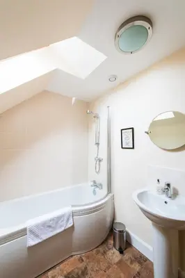 a bathroom with a bath tub and a sink and a bath tub at Keepers Lodge with Hot Tub in Forgandenny