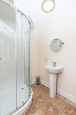 a bathroom with a shower and a sink at Keepers Lodge with Hot Tub in Forgandenny