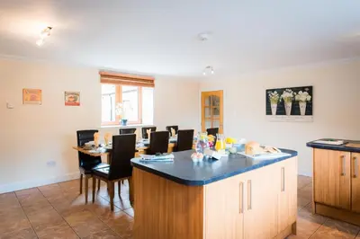 a kitchen and dining room with a table and chairs at The Granary with Hot Tub in Forgandenny