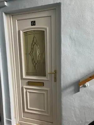 a white door with a sign on it at Budget friendly apartment with stairs Near Glasgow airport and Loch Lomond in Clydebank