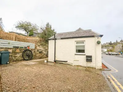 a small white house on the side of a street at The Coach House in Oban