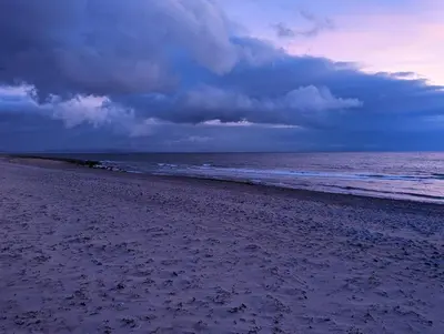 a beach with a cloudy sky and the ocean at The Best Moments Start Here in Corrie