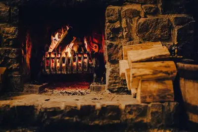 a brick fireplace with a fire in it at The George Hotel in Inveraray