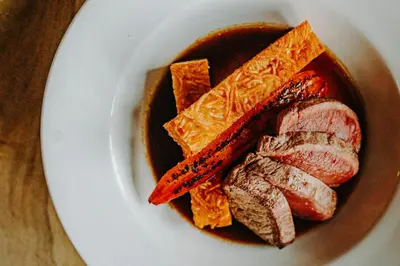 a plate of food with meat and dipping sauce at The George Hotel in Inveraray