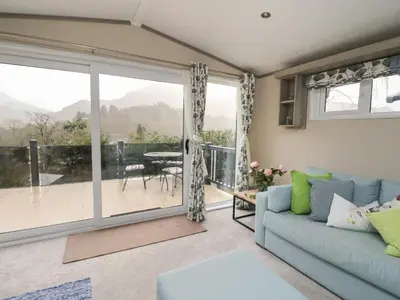 a living room with a couch and a sliding glass door at Rowan in Crieff