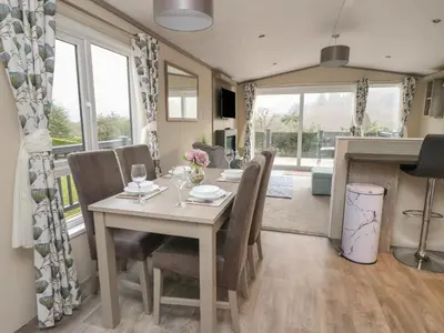 a dining room and kitchen with a table and chairs at Rowan in Crieff