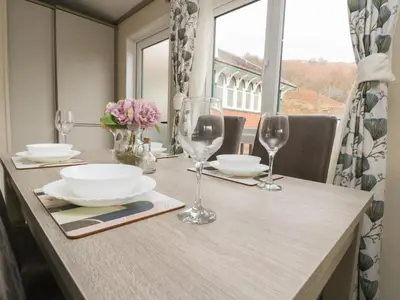 a table with glasses and plates and flowers on it at Rowan in Crieff