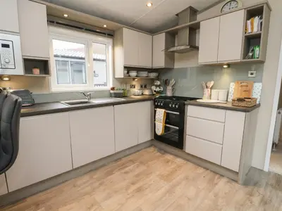 a kitchen with white cabinets and a black stove top oven at Rowan in Crieff