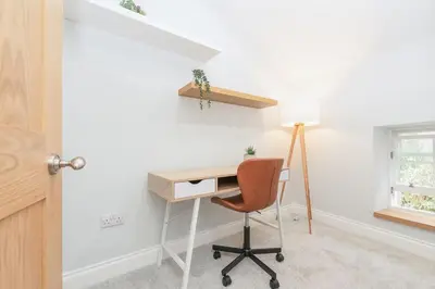 a desk with a chair and a lamp in a room at Dragon Suites - Yukina Suite - 2 bed city centre house with garden in Edinburgh