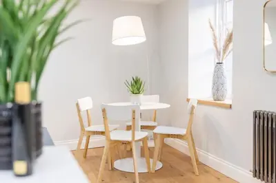 a table and chairs in a living room at Dragon Suites - Yukina Suite - 2 bed city centre house with garden in Edinburgh