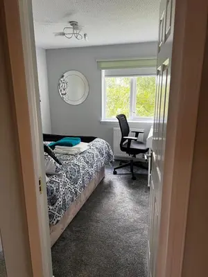 a bedroom with a bed and a desk and a window at 5 minutes to Glasgow airport in Paisley