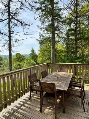 a wooden table and chairs on a wooden deck at Lord Galloway 31 with Hot Tub in Newton Stewart