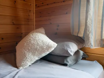 a bed with two pillows next to a window at Chalet Loch Leven Lodge 10 by Interhome in Kinross