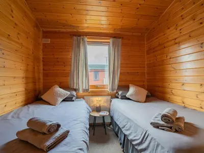 two beds in a log cabin with a window at Chalet Loch Leven Lodge 10 by Interhome in Kinross