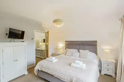 a bedroom with a white bed with towels on it at Lord Galloway 32 with Hot Tub in Newton Stewart