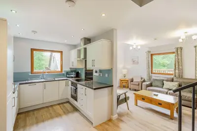 a kitchen and living room with a couch and a table at Lord Galloway 32 with Hot Tub in Newton Stewart