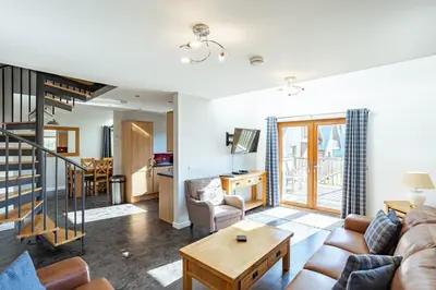 a living room with a couch and a table at Lord Galloway 34 with Hot Tub in Newton Stewart