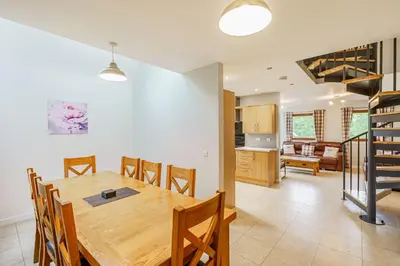 a kitchen and dining room with a wooden table and chairs at Lord Galloway 35 with Hot Tub in Newton Stewart