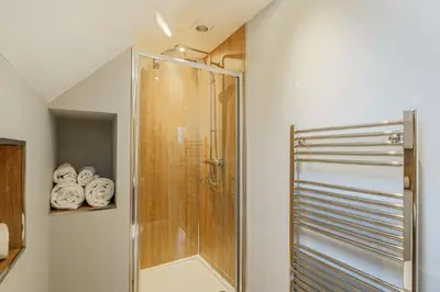 a shower stall in a bathroom with towels at Lord Galloway 36 with Hot Tub in Newton Stewart