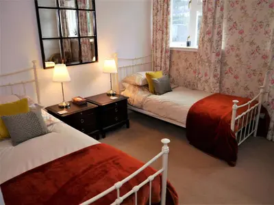 a bedroom with two beds and two lamps and a window at Greenbrae East in Crieff