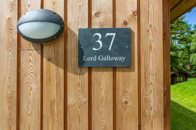 a sign on the side of a wooden fence at Lord Galloway 37 with Hot Tub in Newton Stewart