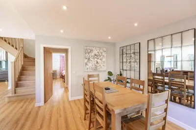 a dining room and living room with a table and chairs at Lord Galloway 38 with Hot Tub in Newton Stewart