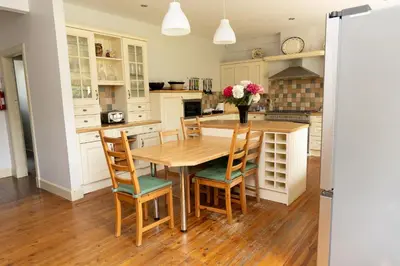 a kitchen with a wooden table and chairs at Newholme House in Stirling