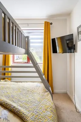 a bedroom with a bunk bed and a flat screen tv at Ochil View Holiday Let in Tullibody