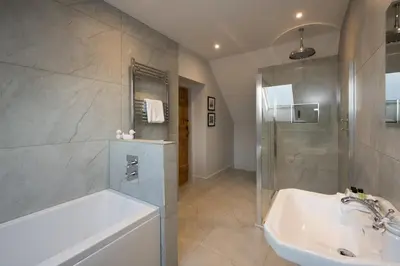 a bathroom with a tub and a shower and a sink at Lapwing - Stylish one bedroom country steading in Perth