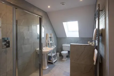 a bathroom with a shower and a toilet and a sink at Lapwing - Stylish one bedroom country steading in Perth