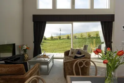 a living room with a large window and a couch at Lapwing - Stylish one bedroom country steading in Perth