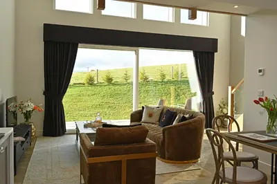 a living room with a couch and a table at Lapwing - Stylish one bedroom country steading in Perth