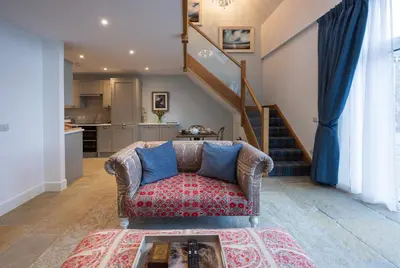a living room with a couch and a staircase at Pigeon Cottage - Luxury country steading in Perth