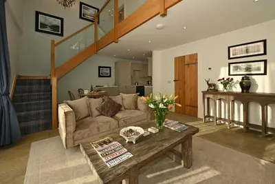 a living room with a couch and a table at Oystercatcher - Converted luxury steading in Perth