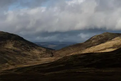 a view of a mountain range with a cloudy sky at Capercaillie Cottage - Luxury converted steading in Perth