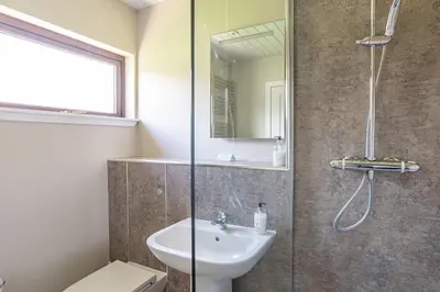 a bathroom with a sink and a glass shower at Birch Lodge 12 with Hot Tub in Newton Stewart