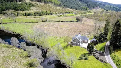 an aerial view of a house next to a river at The Byre in Strathyre