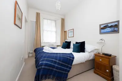 a bedroom with a large bed and a window at Charming Hideaway in Edinburgh City Centre in Edinburgh