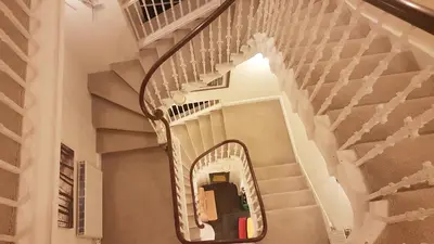 a stairway with a spiral staircase in a house at Langhouse Castle Bed and Breakfast in Inverkip