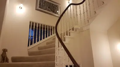 a staircase in a home with a white stair case at Langhouse Castle Bed and Breakfast in Inverkip
