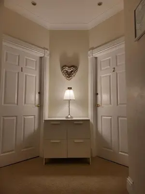 a lamp on a dresser in a room with two doors at Langhouse Castle Bed and Breakfast in Inverkip