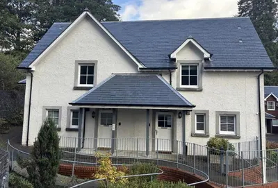 a white house with a black roof at Brodie Cottage in Killin