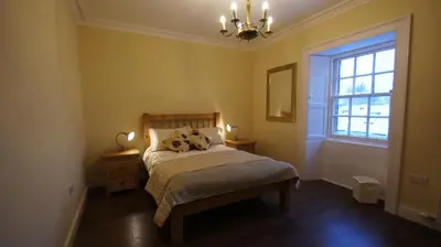 a bedroom with a bed and a window at Comrie Old Schoolhouse in Comrie