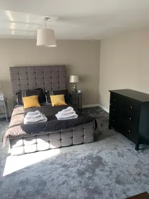 a bedroom with a large bed with yellow pillows at Elegant bungalow in Newmilns, East Ayrshire in Newmilns