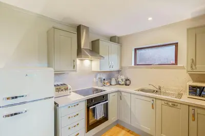 a kitchen with white cabinets and a white refrigerator at Birch Lodge 13 with Hot Tub in Newton Stewart