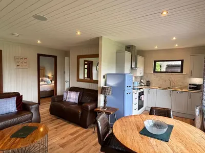 a kitchen and a living room with a table at Birch Lodge 14 with Hot Tub in Newton Stewart