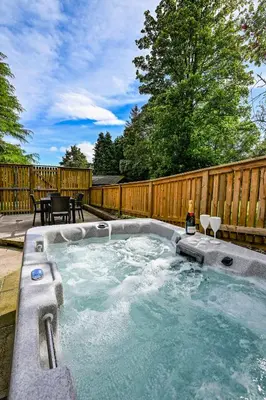 a hot tub in a backyard with a wooden fence at Birch Lodge 18 with Hot Tub in Newton Stewart