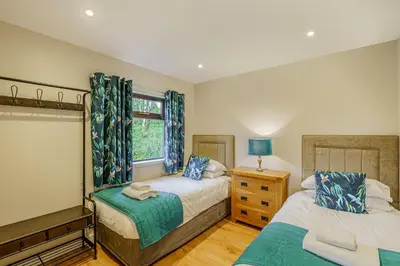 a bedroom with two beds and a window at Birch Lodge 22 with Hot Tub in Newton Stewart