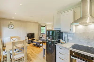 a kitchen with a counter and a dining room at Birch Lodge 23 with Hot Tub in Newton Stewart