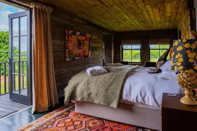 a bedroom with a bed and a balcony at The Artist's House at Jupiter Artland in Kirknewton